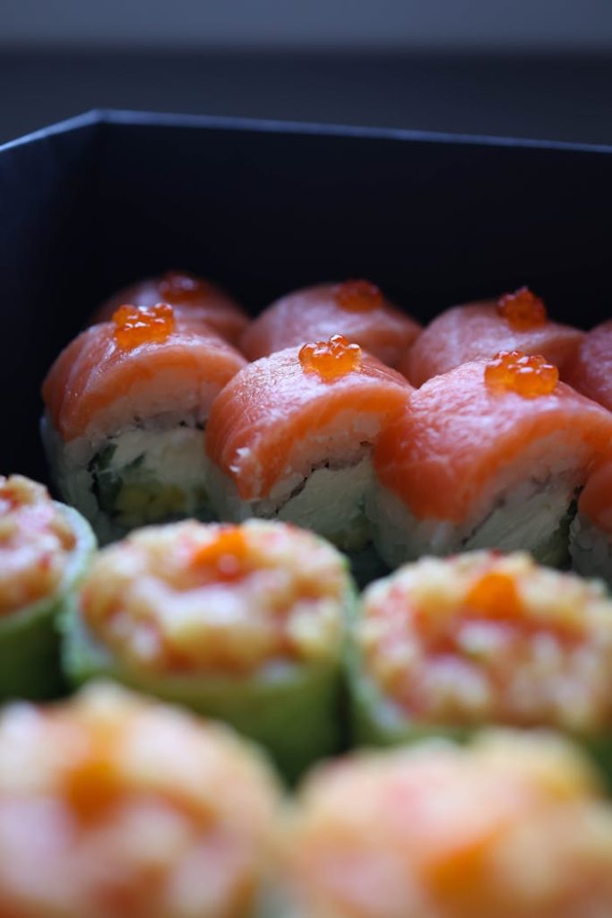 pexels-photo-29143190 Close-up of vibrant sushi rolls with fresh salmon and roe topping, showcasing Japanese cuisine.